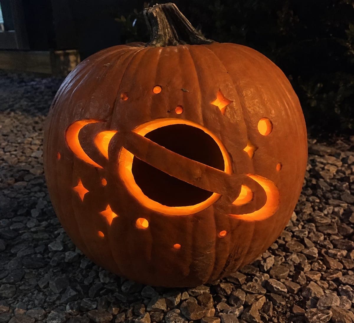 Glowing Ringed Planet Galaxy Pumpkin on a Gravel Path