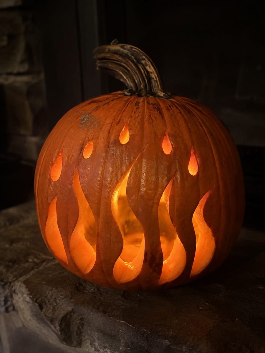 Layered Flame Pumpkin with Ember Holes on a Hearth