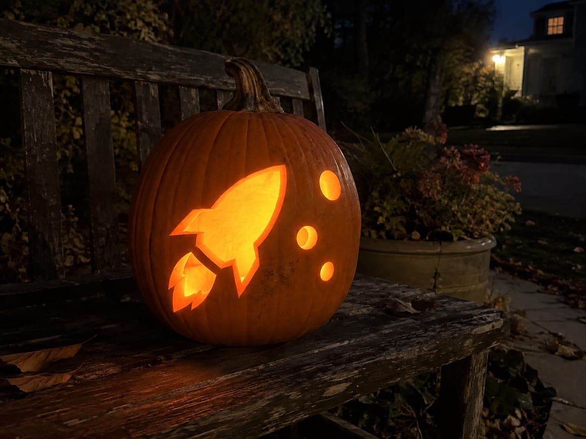 Rocket Ship Cutout Pumpkin Glowing on a Garden Bench