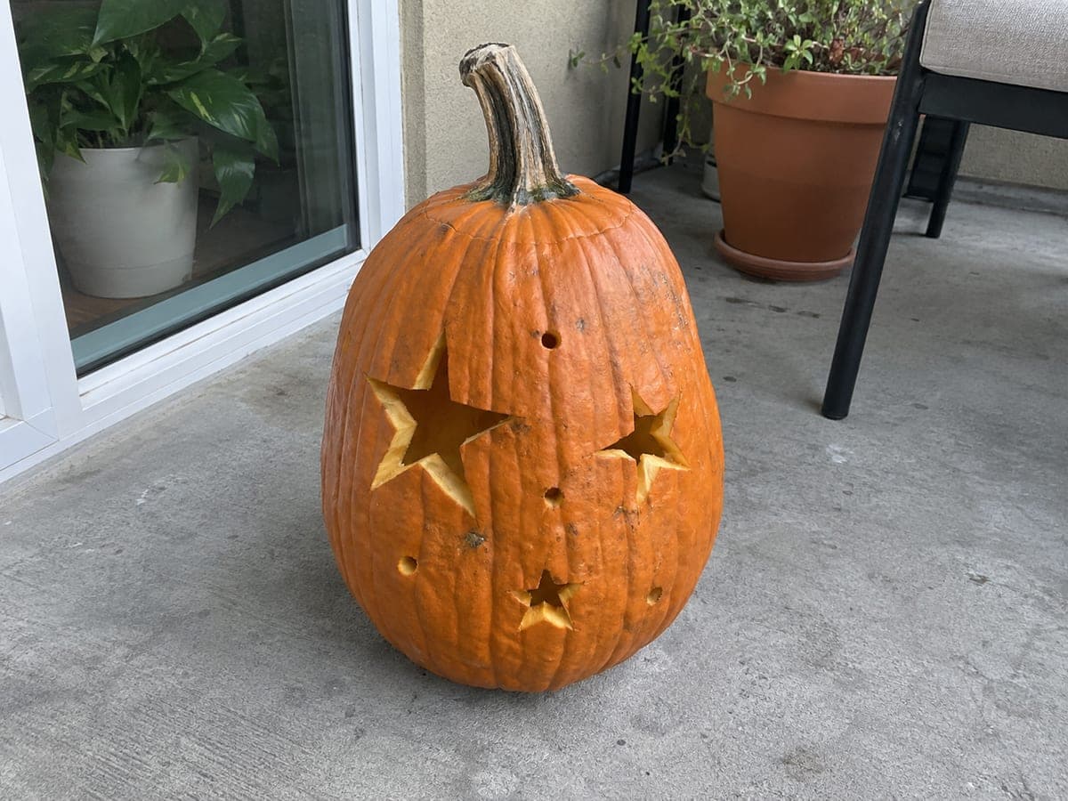 Star Cutout Pumpkin on a Concrete Balcony at Night