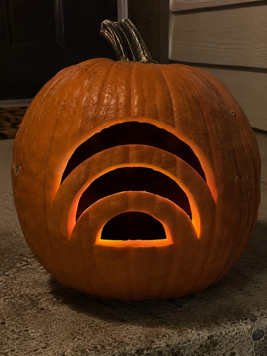 Three Glowing Rainbow Arch Pumpkin on a Concrete Step